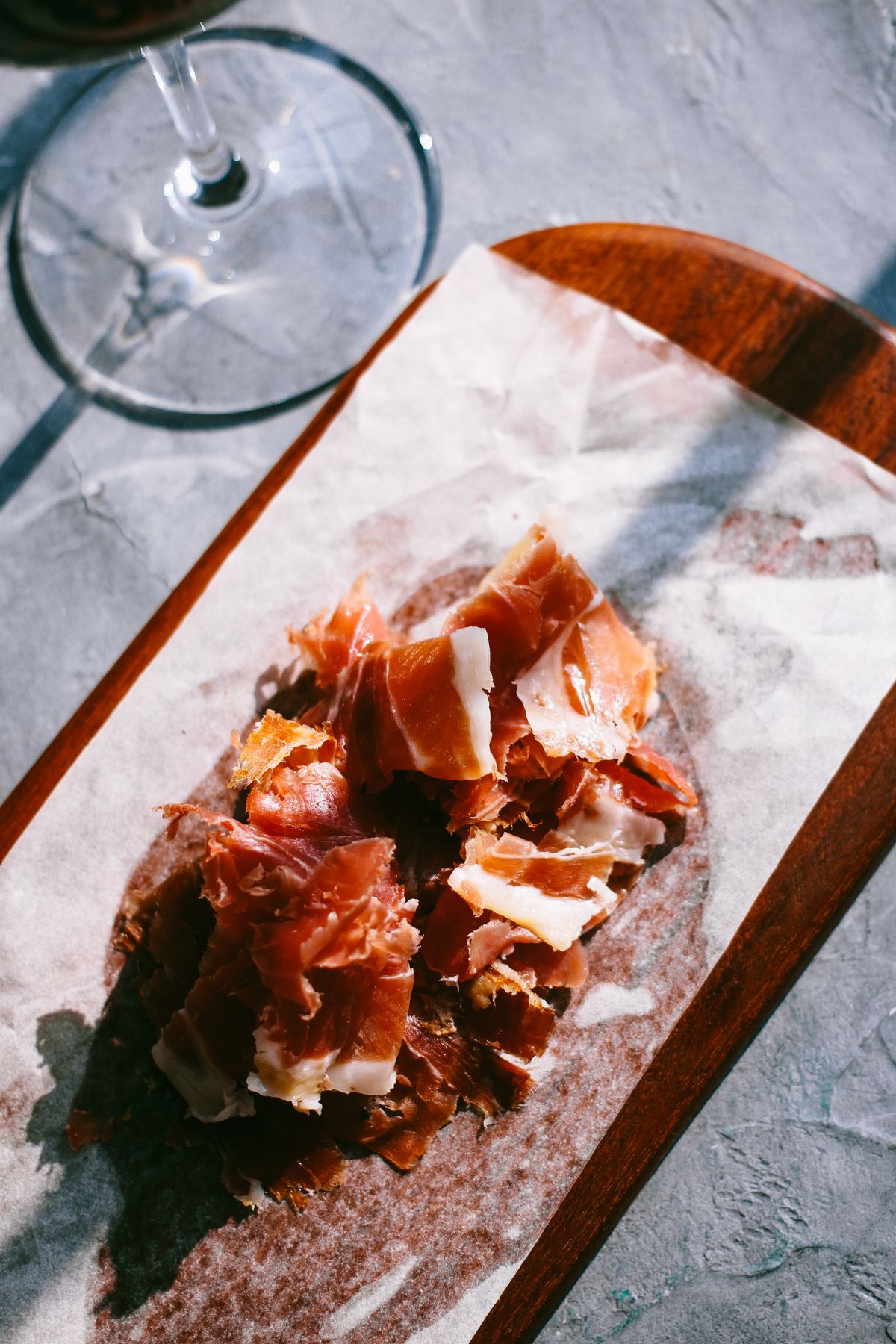 Lonchas de jamón ibérico en tabla de madera para conservar correctamente